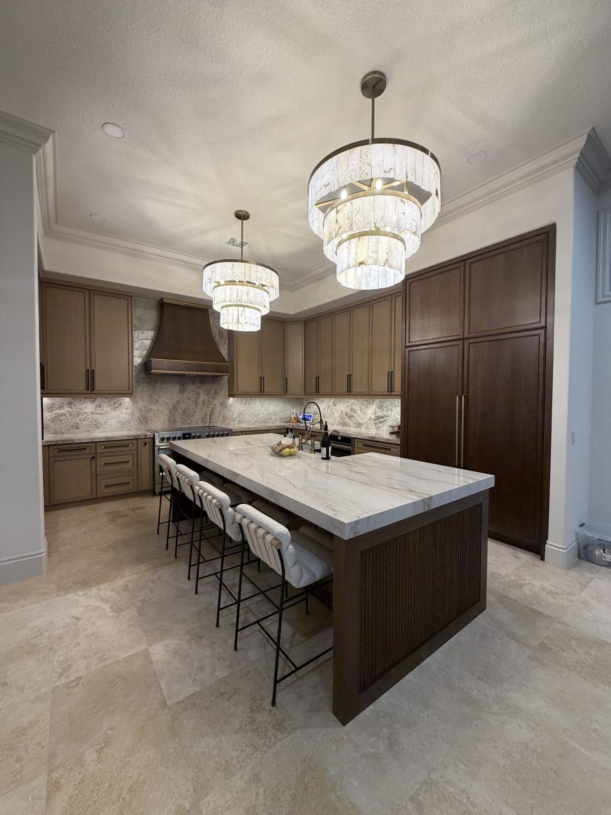 Custom walnut kitchen island with quartzite countertop and crystal chandeliers by Mike's Magic