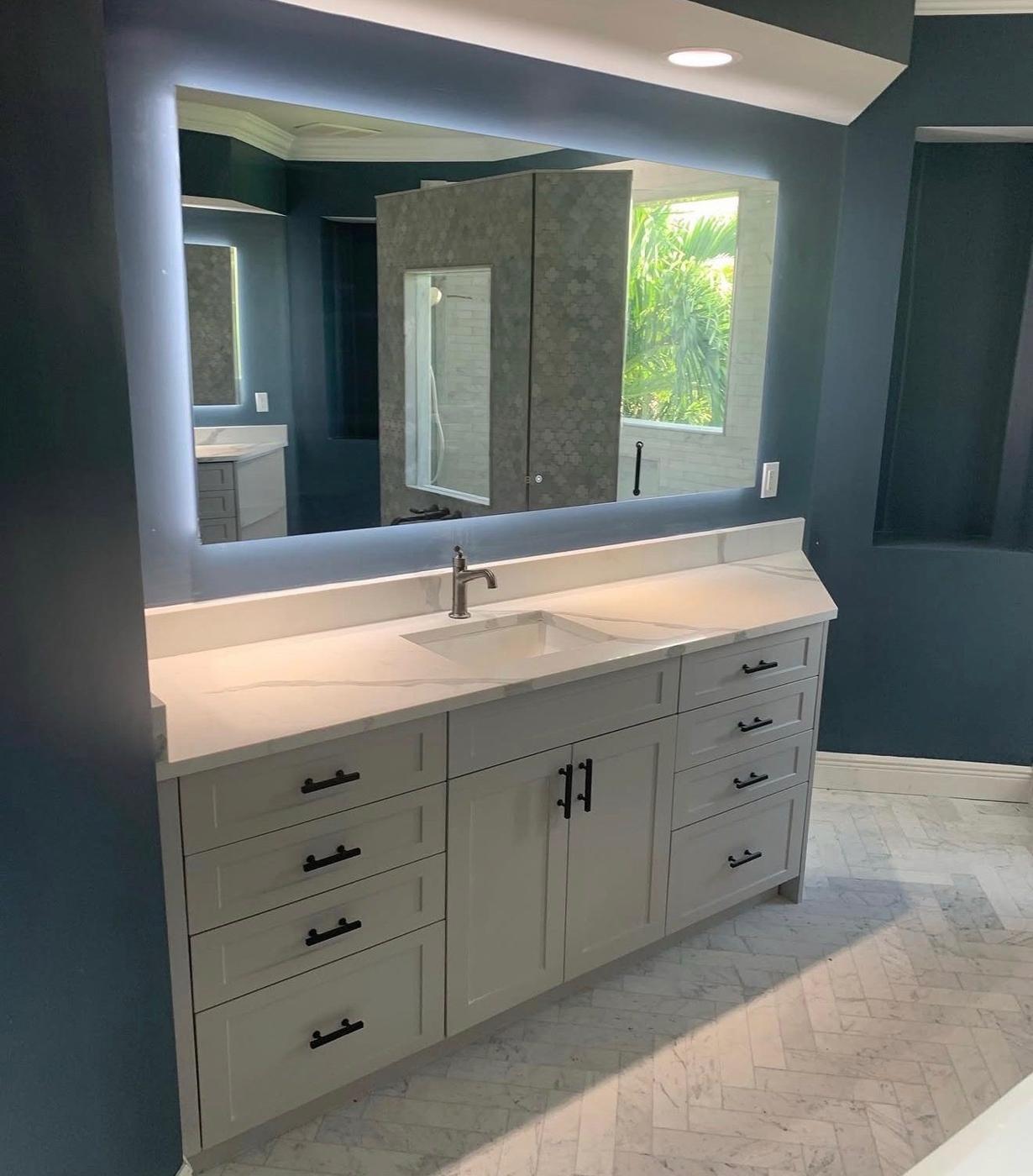 Remodeled bathroom with custom vanity and lighted mirror