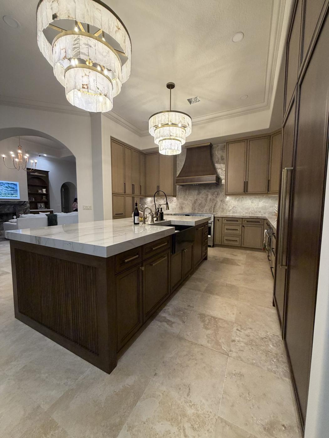 Custom walnut kitchen with quartzite island and crystal chandeliers